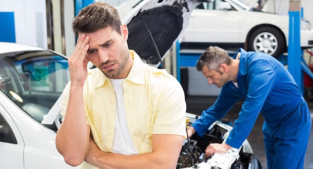 Worried customer with mechanic looking at car